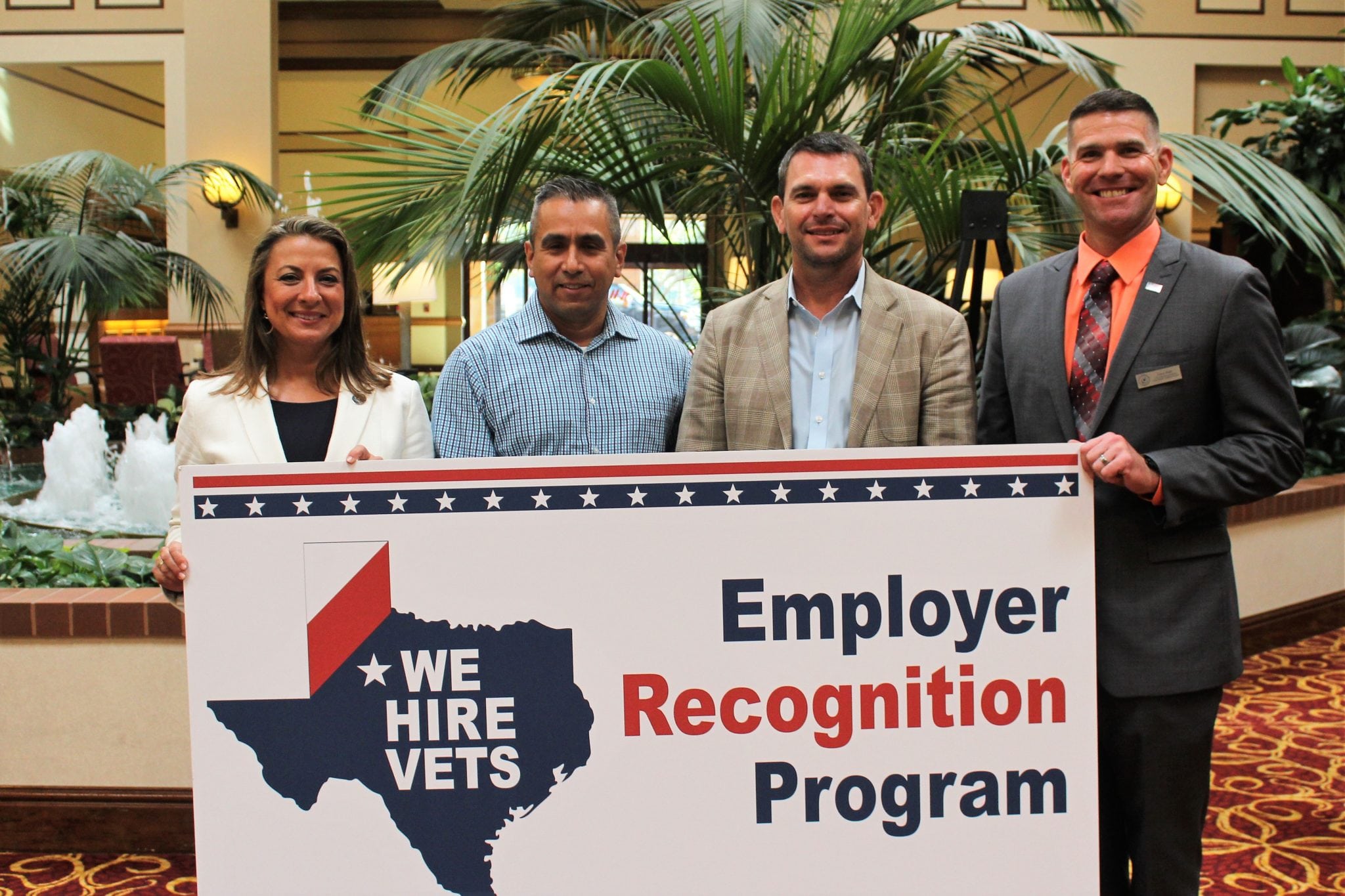 Contigo Technology team holding "we hire vets" sign